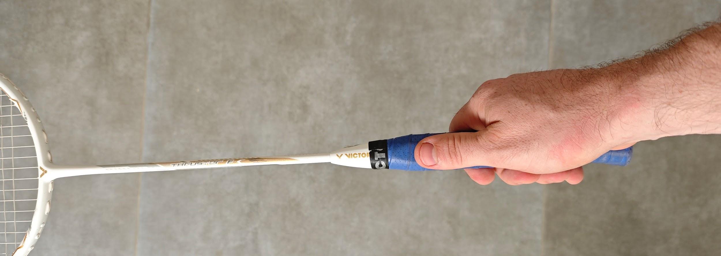 Hand holding a racket with a thumb grip